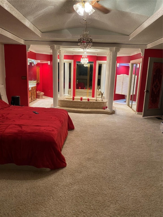 bedroom featuring ornate columns, carpet flooring, a textured ceiling, and ensuite bath