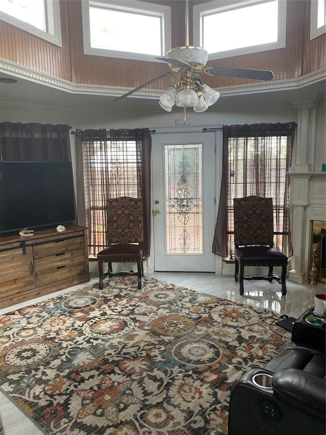 living area with ceiling fan, a high ceiling, and a healthy amount of sunlight