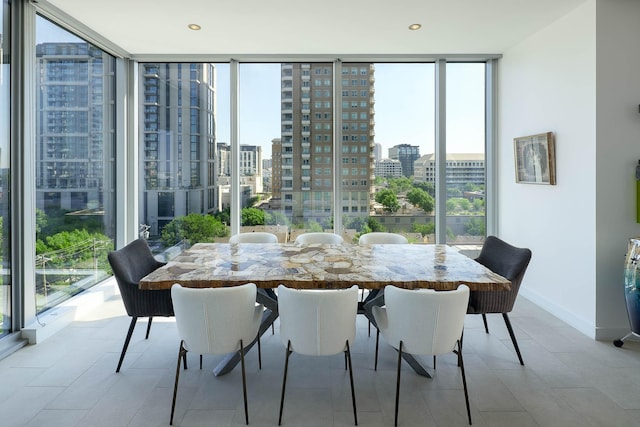 dining room with a view of city, expansive windows, and baseboards