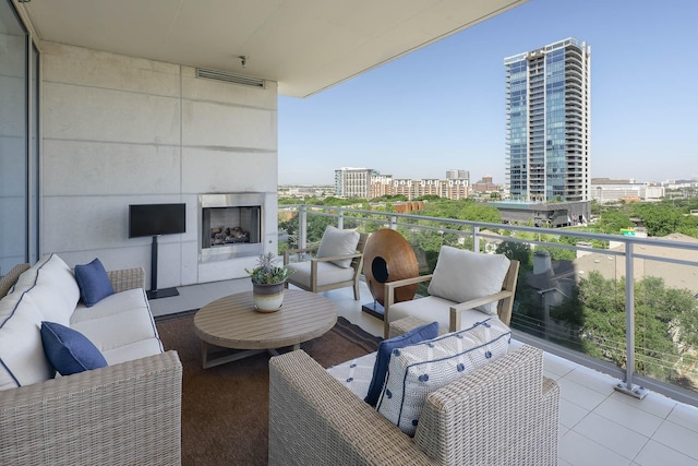 balcony with an outdoor living space with a fireplace