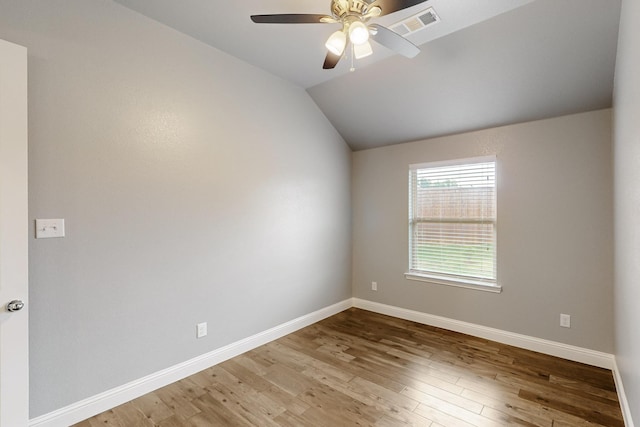 empty room with ceiling fan, baseboards, wood finished floors, lofted ceiling, and visible vents