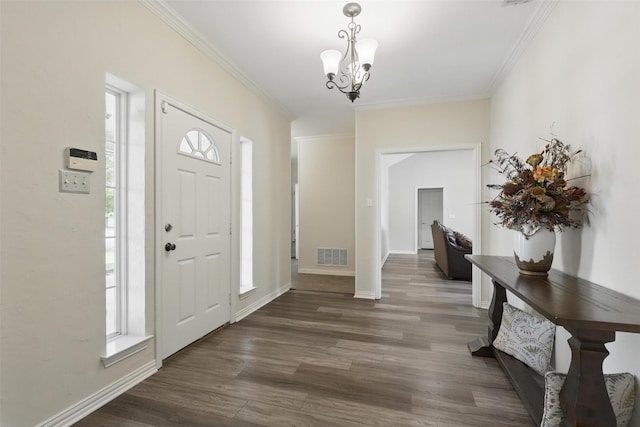 foyer featuring visible vents, wood finished floors, a wealth of natural light, and an inviting chandelier