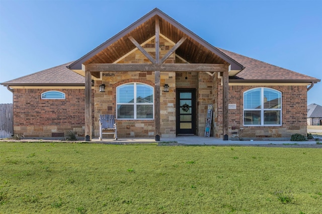 exterior space featuring a front lawn and roof with shingles