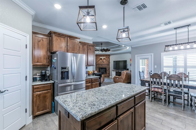 kitchen with visible vents, ceiling fan, a stone fireplace, and stainless steel fridge with ice dispenser
