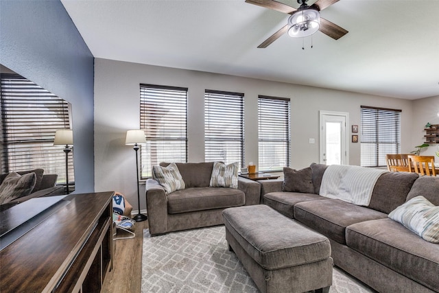 living room featuring wood finished floors, ceiling fan, and a healthy amount of sunlight