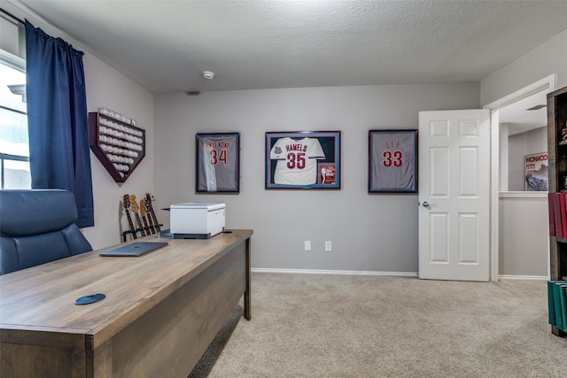 carpeted office space with a textured ceiling and baseboards