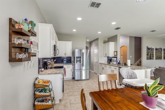 kitchen with open shelves, visible vents, appliances with stainless steel finishes, and white cabinetry