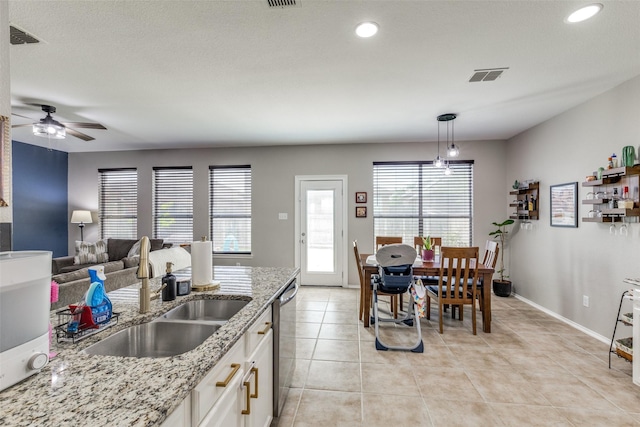 kitchen with light tile patterned floors, white cabinetry, a sink, ceiling fan, and visible vents