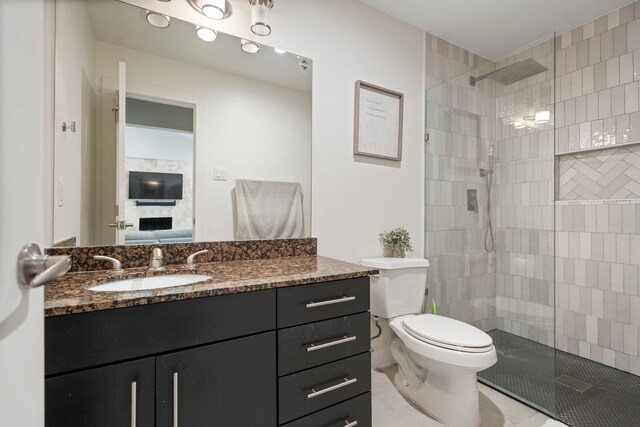 full bath with tile patterned floors, a walk in shower, vanity, and toilet
