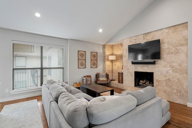 living room featuring recessed lighting, wood finished floors, a fireplace, and lofted ceiling