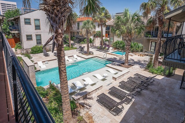 pool featuring fence, a community hot tub, and a patio area