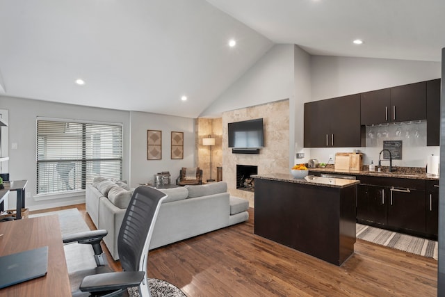 kitchen with a center island, recessed lighting, open floor plan, and a sink