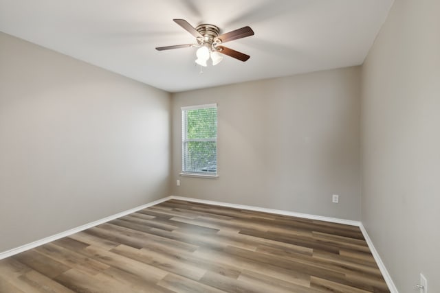 unfurnished room with baseboards, wood finished floors, and a ceiling fan