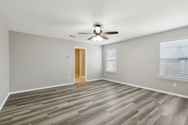 unfurnished room featuring baseboards, wood finished floors, and ceiling fan
