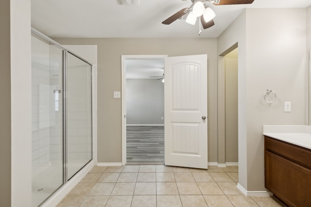 full bath with tile patterned floors, a shower stall, vanity, baseboards, and a ceiling fan
