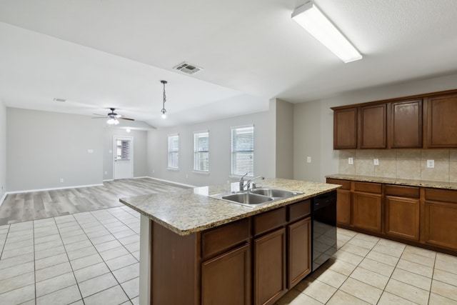 kitchen featuring black dishwasher, light tile patterned floors, visible vents, and a sink
