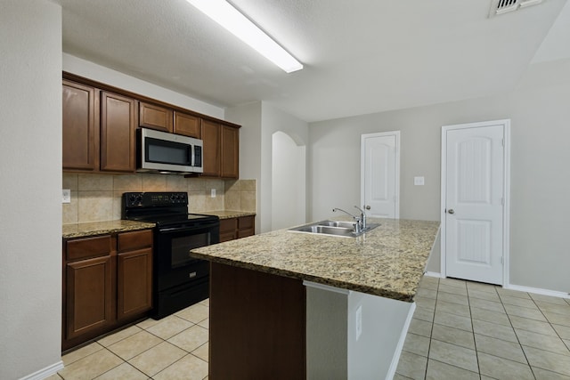 kitchen with black range with electric stovetop, light tile patterned flooring, stainless steel microwave, and a sink