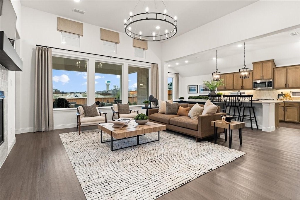 4047 Bedford, Crandall, TX 75114 - living area featuring recessed lighting, a chandelier, a glass covered fireplace, dark wood-type flooring, and baseboards