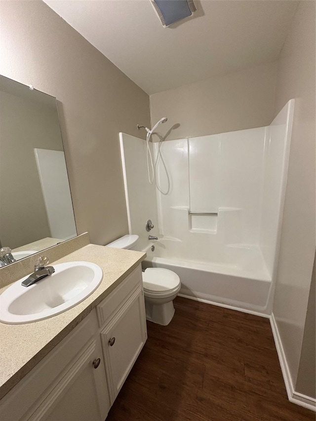 bathroom featuring toilet, vanity, bathing tub / shower combination, and wood finished floors