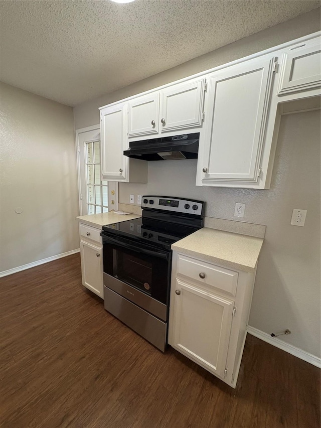 kitchen with under cabinet range hood, dark wood-type flooring, stainless steel range with electric cooktop, baseboards, and white cabinets