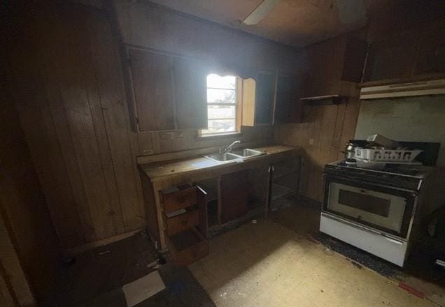 kitchen featuring gas range oven, light countertops, and a sink