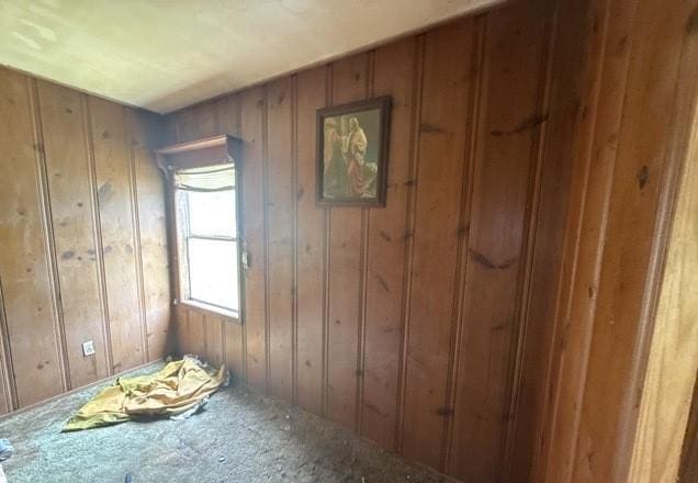 unfurnished room with wood walls
