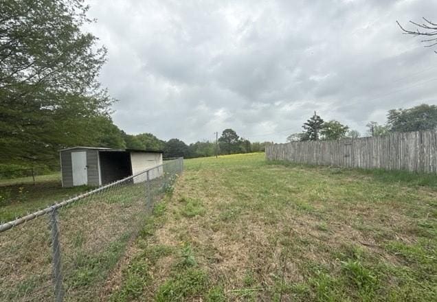 view of yard with an outbuilding and fence