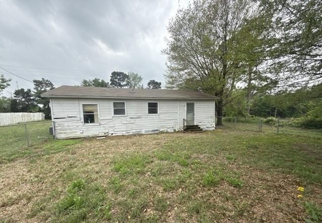 back of house with fence, entry steps, and a yard