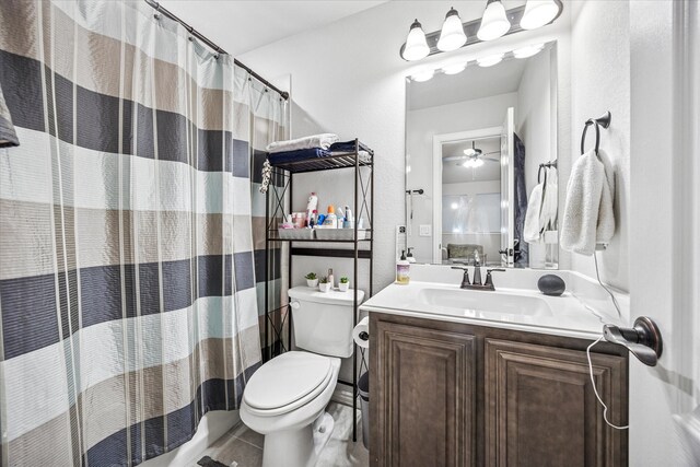 full bath with toilet, curtained shower, vanity, and a textured wall