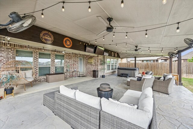 view of patio / terrace featuring fence, ceiling fan, an outdoor hangout area, and a hot tub