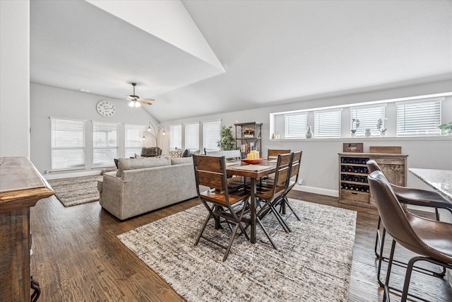 dining space featuring lofted ceiling, dark wood-type flooring, ceiling fan, and baseboards