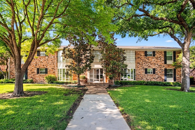 view of front of property featuring brick siding and a front lawn