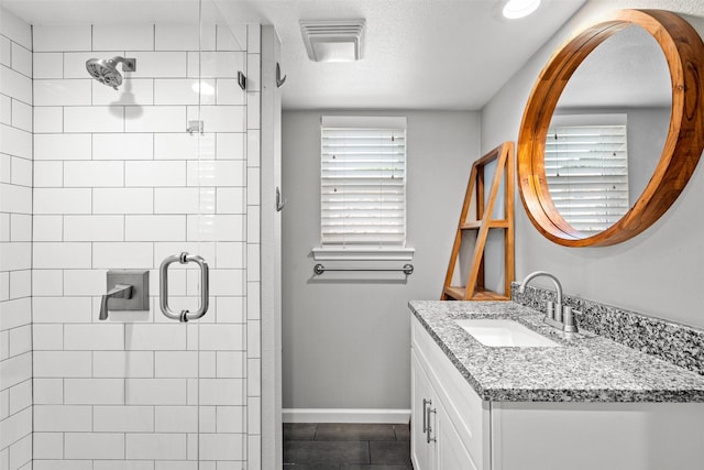 full bath featuring tile patterned floors, vanity, a stall shower, and baseboards