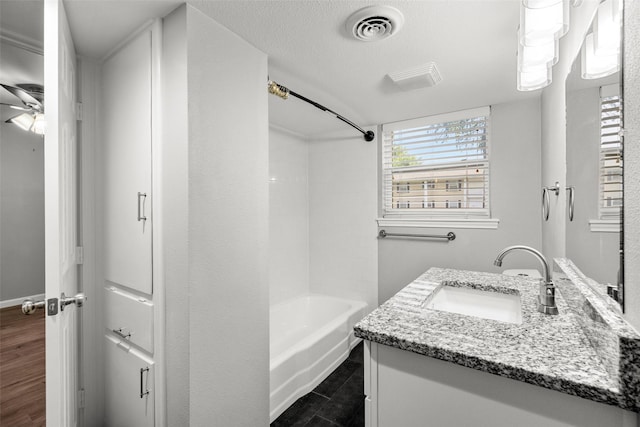 bathroom with visible vents, bathtub / shower combination, and vanity
