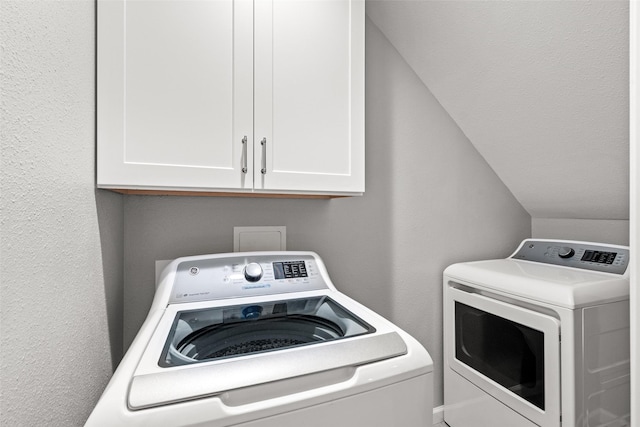 washroom with washer and clothes dryer and cabinet space