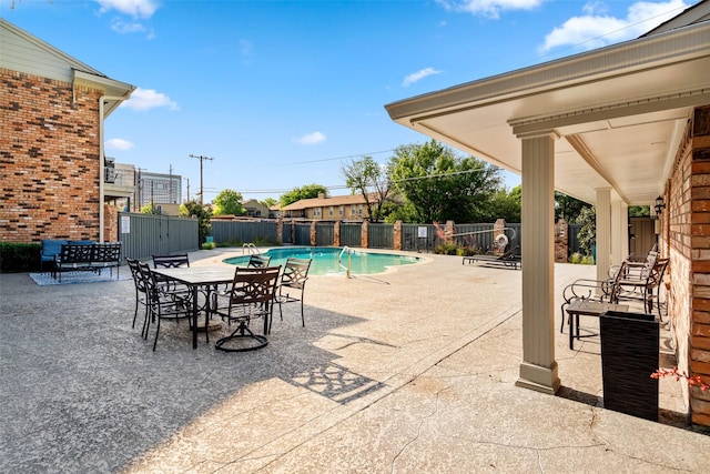 view of pool featuring a patio, outdoor dining space, a fenced backyard, and a fenced in pool