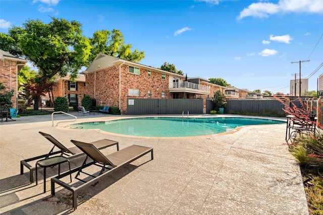 community pool with fence and a patio area