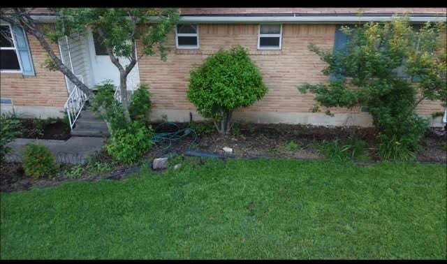 view of property exterior with a lawn and brick siding