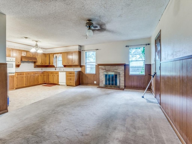 1413 Sylvan Dr, Arlington, TX 76012 - unfurnished living room featuring wooden walls, a textured ceiling, plenty of natural light, and a brick fireplace