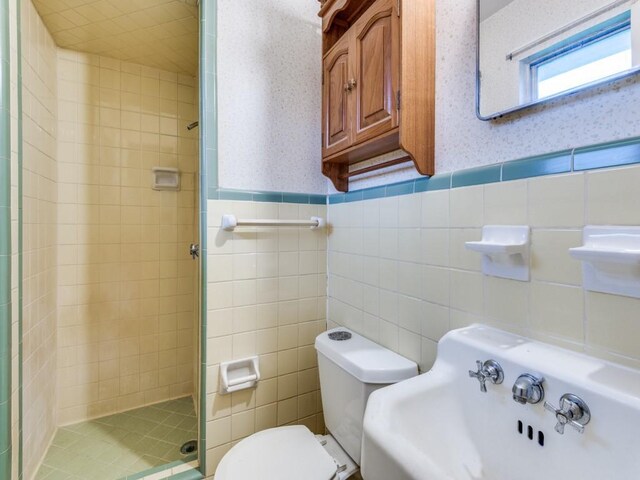 1413 Sylvan Dr, Arlington, TX 76012 - full bath with a stall shower, tile walls, toilet, and wallpapered walls