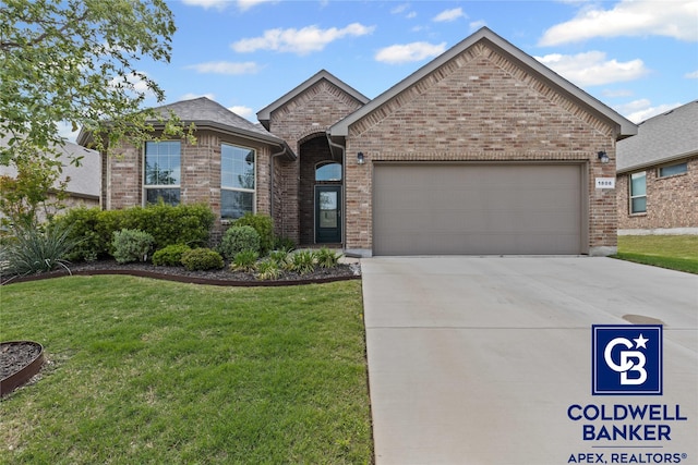 french country home with concrete driveway, a garage, a front lawn, and brick siding