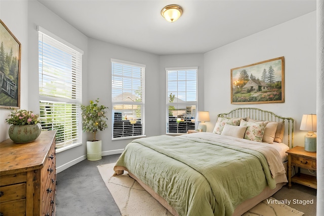 carpeted bedroom featuring baseboards and multiple windows