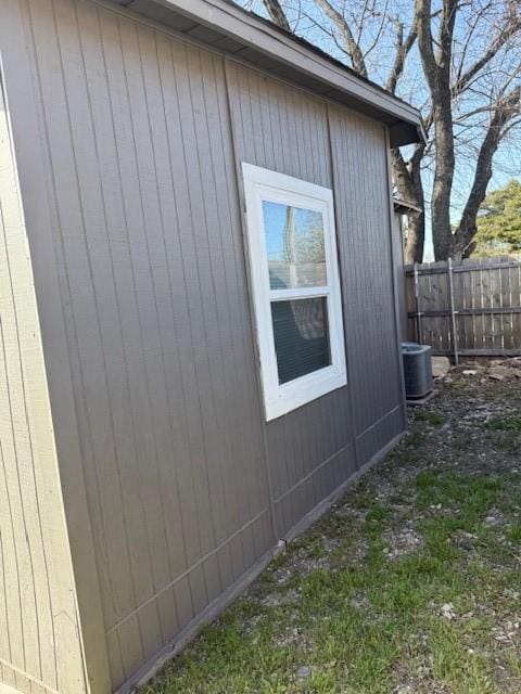 view of side of home featuring fence and central AC unit