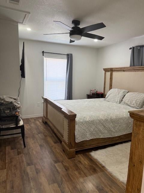 bedroom featuring ceiling fan, visible vents, dark wood finished floors, and baseboards