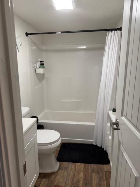 bathroom featuring wood finished floors, shower / bath combination with curtain, toilet, and vanity