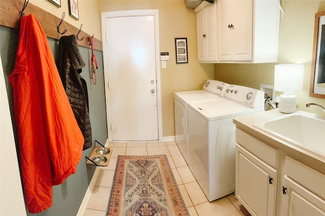 clothes washing area featuring baseboards, separate washer and dryer, a sink, cabinet space, and light tile patterned floors