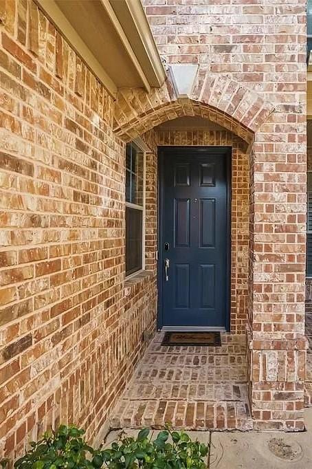 doorway to property with brick siding