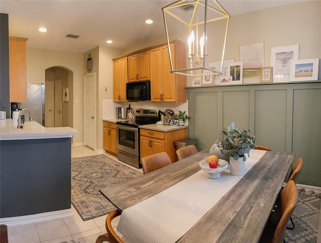 1861 Sandpiper Ln, Carrollton, TX 75007 - kitchen featuring stainless steel appliances, arched walkways, a chandelier, light countertops, and light tile patterned flooring
