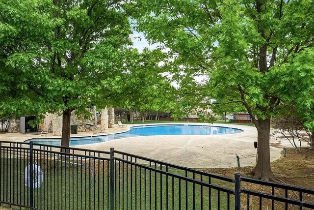 community pool featuring fence and a patio area