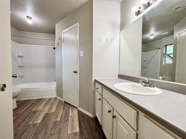 1809 Ramada Dr, Waco, TX 76712 - full bath with wood finished floors, vanity, shower / bathtub combination, and a textured ceiling